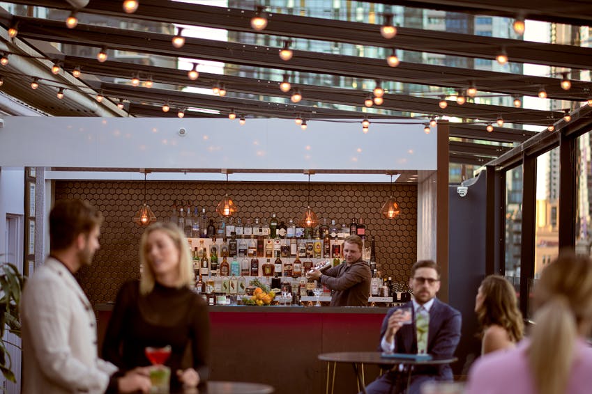 A bartender mixing a drink at a rooftop bar.